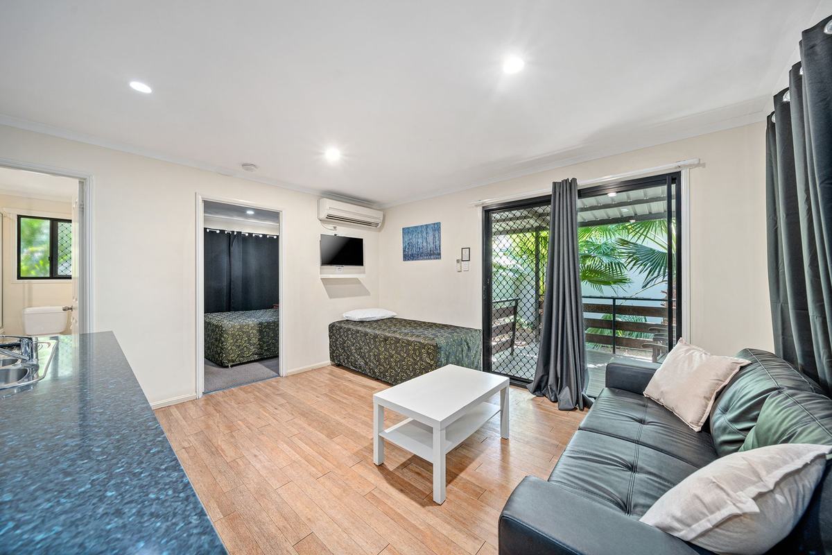 Living area with sofa and balcony doors in the Executive Queen & Single apartment